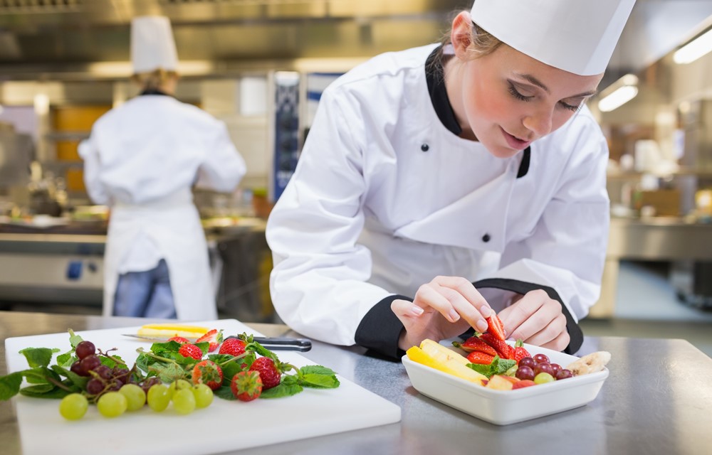 Restaurant with chef arranging dish